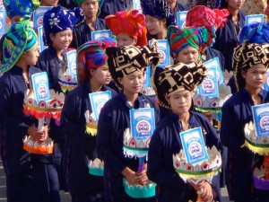 Reise in Myanmar in Asien. Burmesische Frauen in traditioneller Kleidung und mit typisch burmesischer Kopfbedeckung nehmen an der Prozession des burmesischen Nationalfeiertags PaO in der Stadt Taunggyi teil.