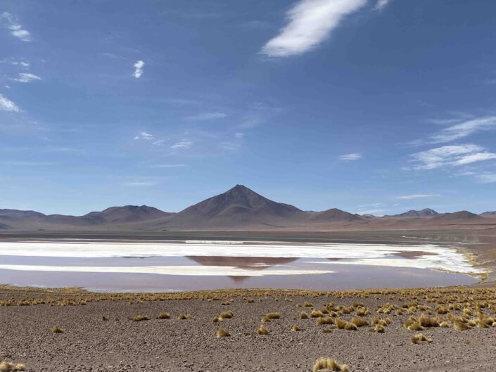 Reise in Bolivien in Südamerika. Naturbild vom Hochland Altiplano mit einem Salzsee vor der hohen Bergkette des Anden Gebirges.