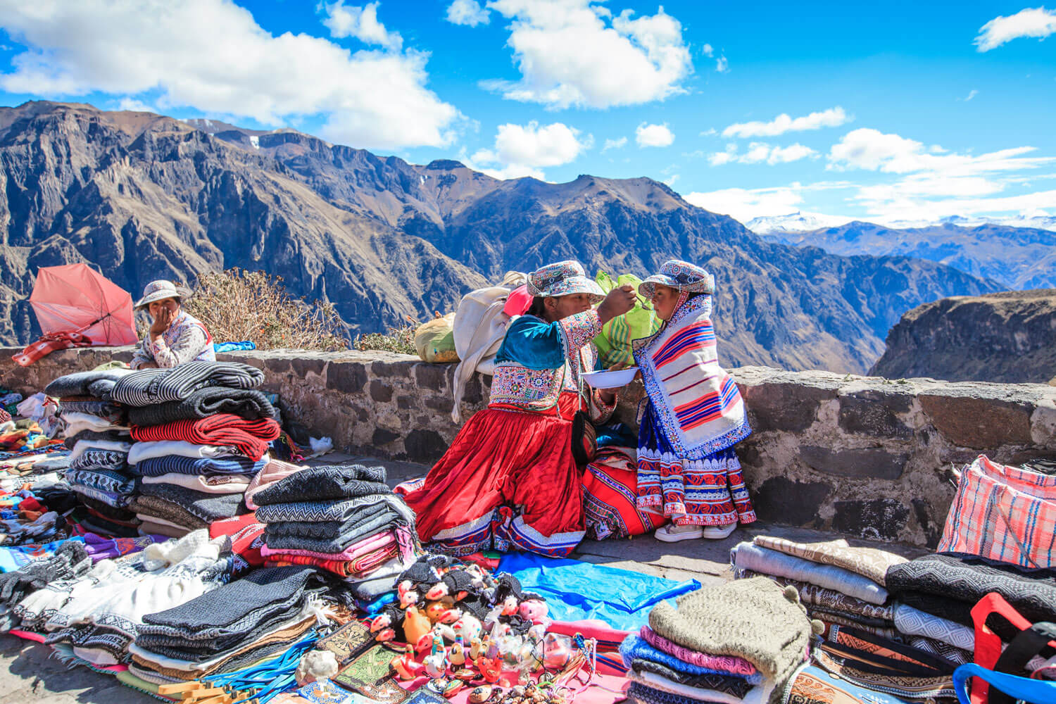 Frauen in traditionellen Trachten aus dem peruanischen Andenhochland. Verkauf von Produkten aus Alpakawolle.