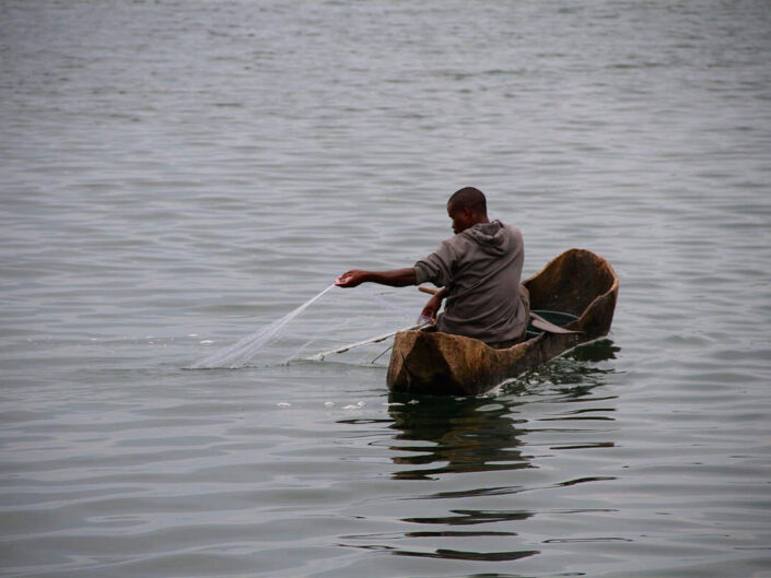 Fischer in Einbaumboot auf dem See